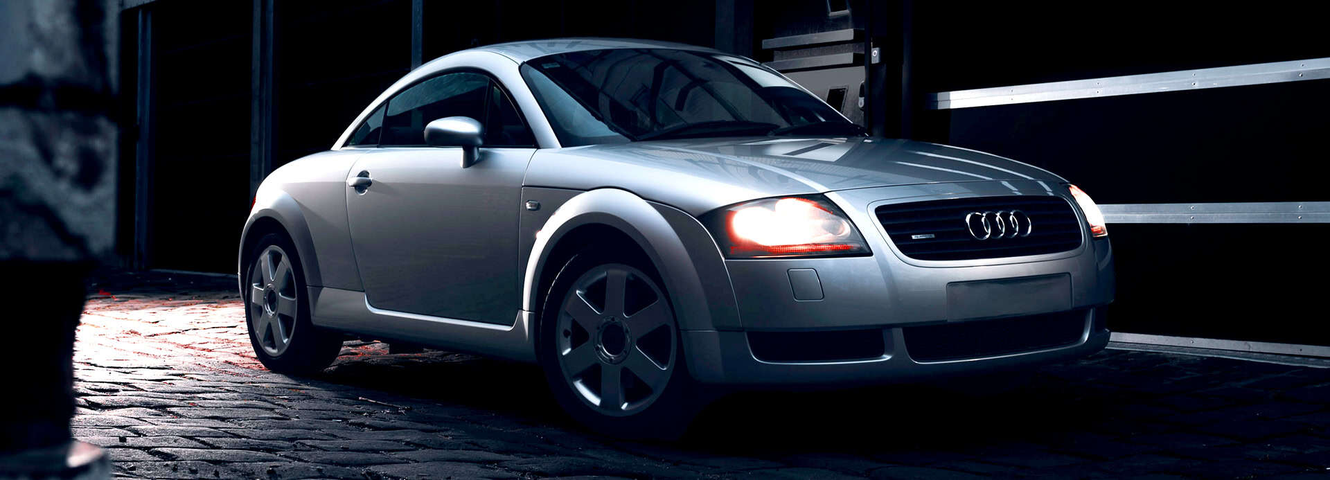 Audi TT silver sports car parked in a modern industrial garage.