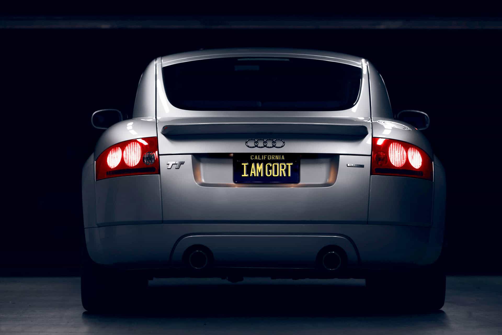 Custom license plate reading "I AM GORT" on silver Audi TT SPORTS CAR at night, emphasizing unique branding and luxury vehicle, ideal for automotive branding and premium car marketing.